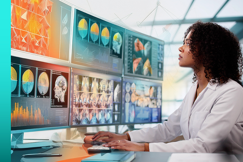A professional sits at a desk and examines X-ray images across their multiple monitors.
