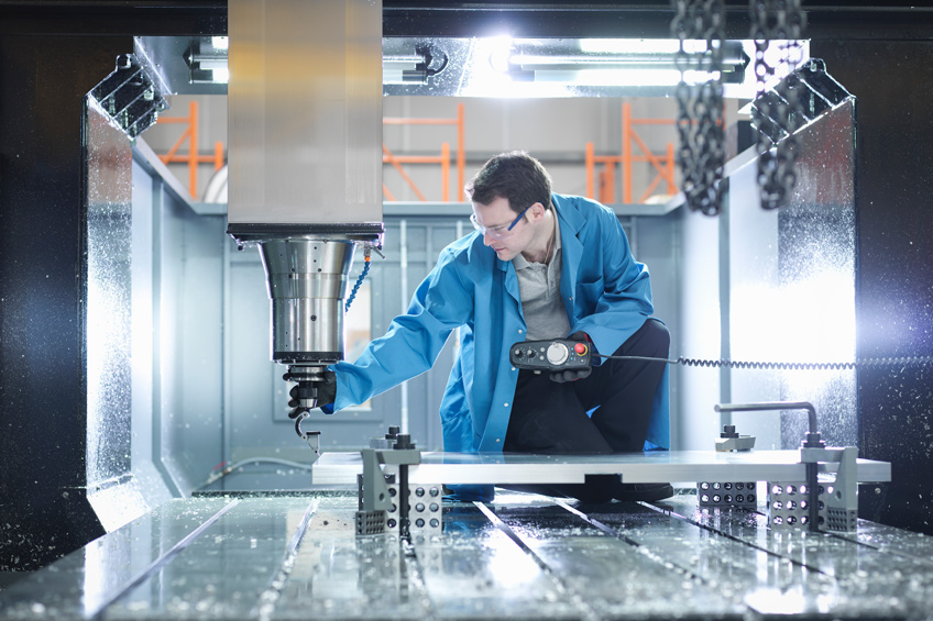 Worker in a manufacturing space inspecting equipment